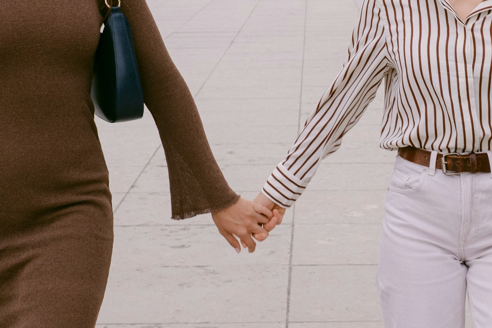 Two people holding hands while walking
