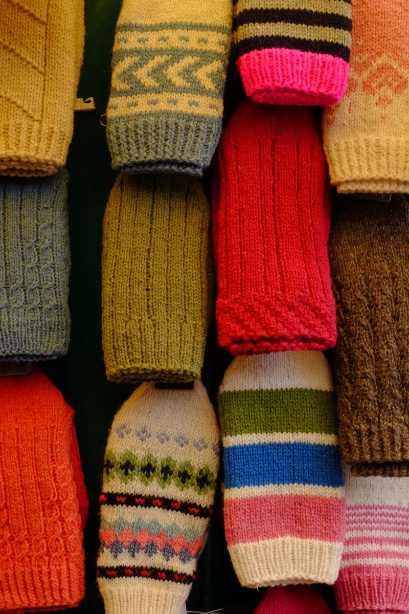 a group of knitted hats and mittens hanging on a wall
