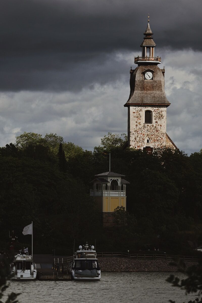 A large clock tower towering over a body of water